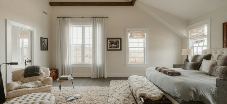 Spacious bedroom with a large bed and a cosy seating area, ideal for reading