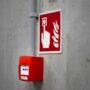 Red fire alarm button on an industrial concrete wall, ready to be triggered